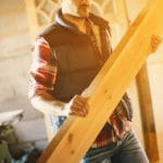Construction man holding a wood beam